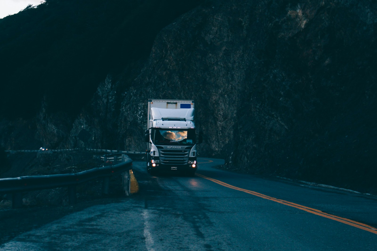 trailer truck passing on road near rail guard, commercial auto
