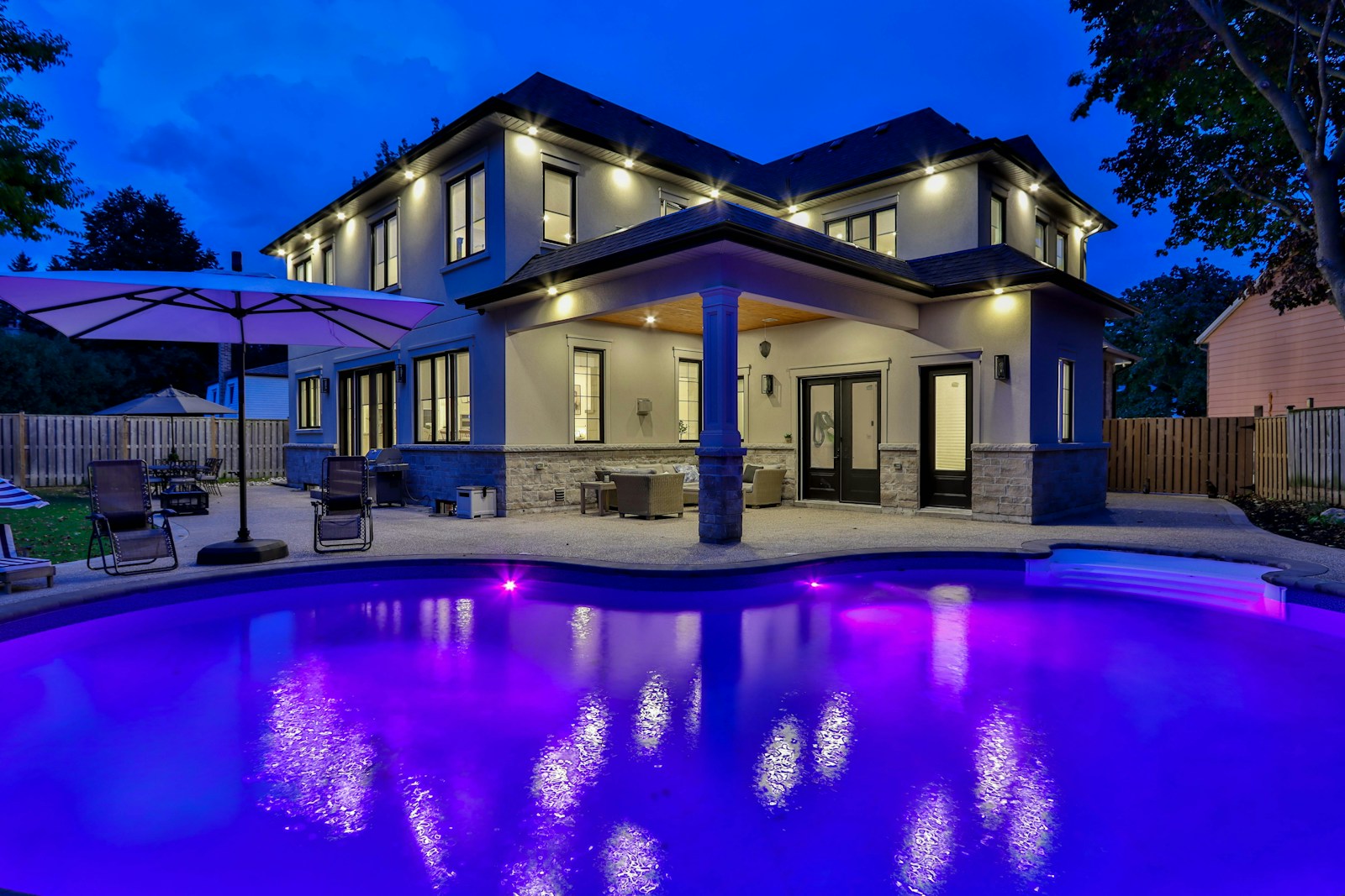 white concrete building near swimming pool during night time, home